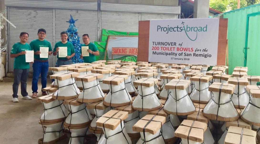 Projects Abroad teenage volunteers doing construction work in the Philippines deliver 200 toilet bowls to the local community. Teenage volunteers doing building work in the Philippines hand over 200 toilet bowls to a local community.